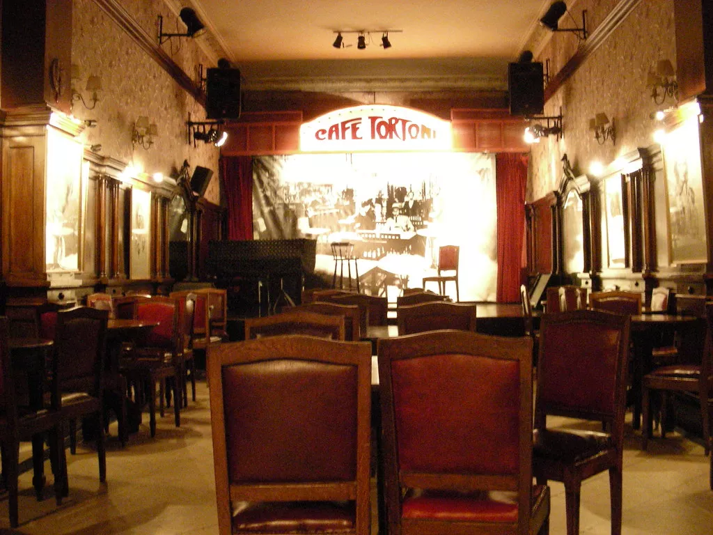 O ambiente histórico do Café Tortoni Interior do Café Tortoni, com suas colunas e decoração clássica.